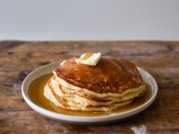 Stack of Pancakes topped with Butter and Maple Syrup