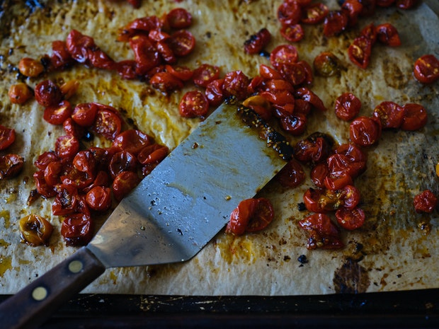 Roasted cherry tomatoes on a baking sheet