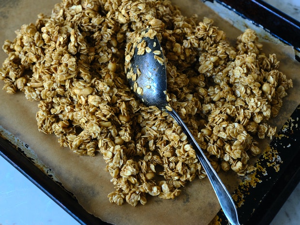 granola spread across a baking sheet prior to baking