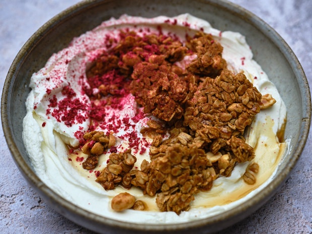 peanut butter granola topping yogurt in a ceramic bowl