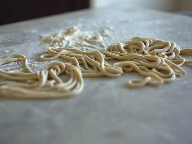 Pici pasta tangled on a marble countertop