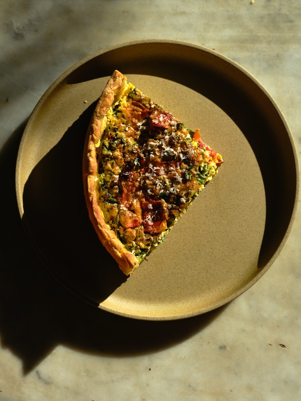 a perfect wedge of quiche pictured from overhead on a small plate