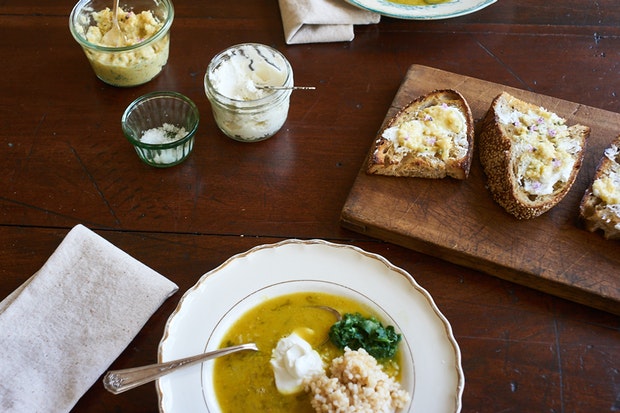 table set with two bowls of red lentil soup with a side of bread